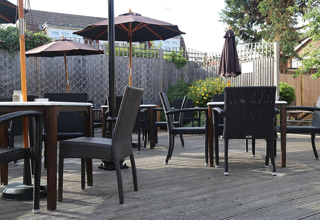 Terrasse en bois aménagée avec tables, chaises et parasols