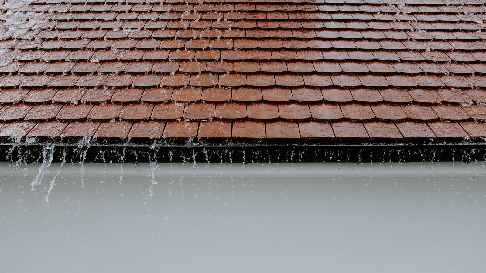 Eau de pluie ruisselant sur des tuiles de toiture traitées à l'hydrofuge