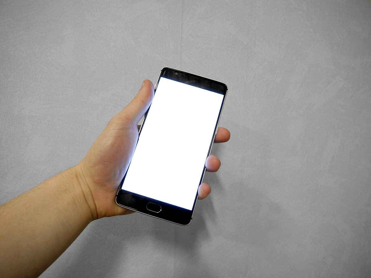 Main tenant un smartphone, pour relancer un devis par message ou appel