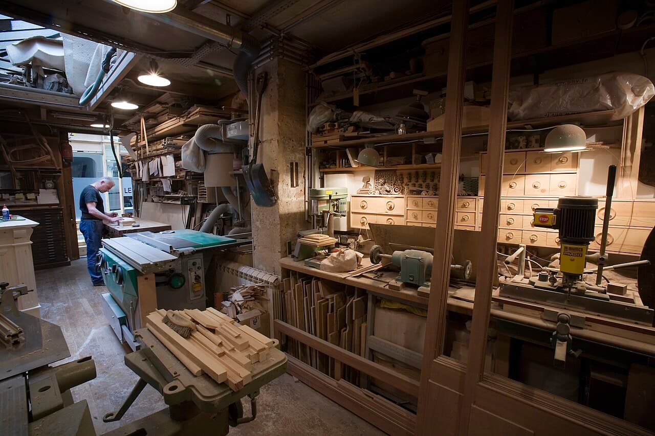Artisan menuisier au travail dans son atelier équipé